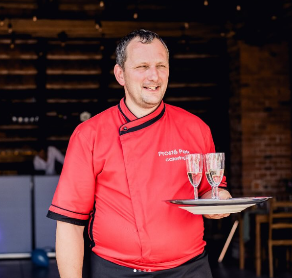 Petr z Prostě Petr cateringu s tácem a sklenkami
