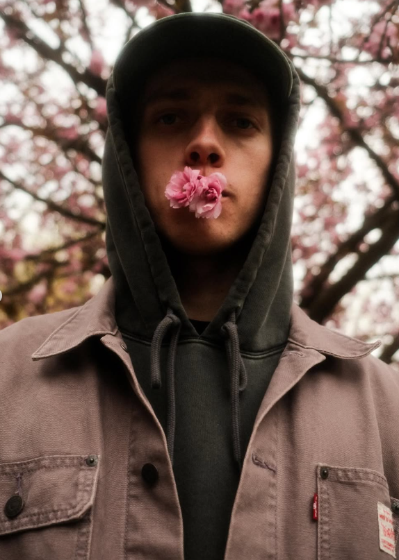 Portrét fotografa Zdeňka Jindry mezi rozkvetlými stromy